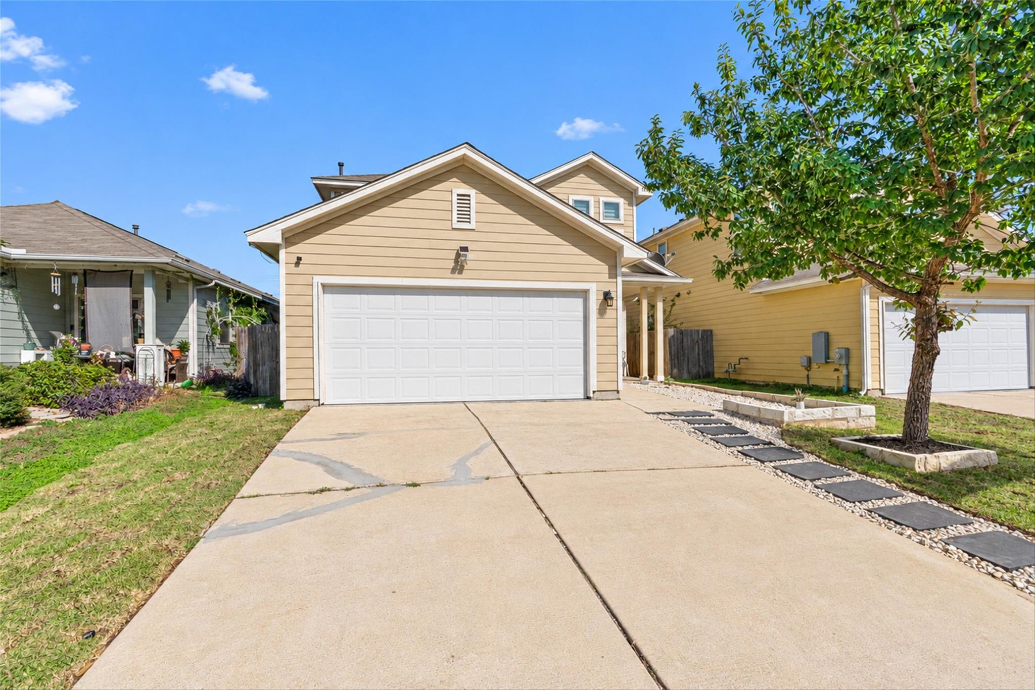 A concrete driveway leads to the front-loading ga