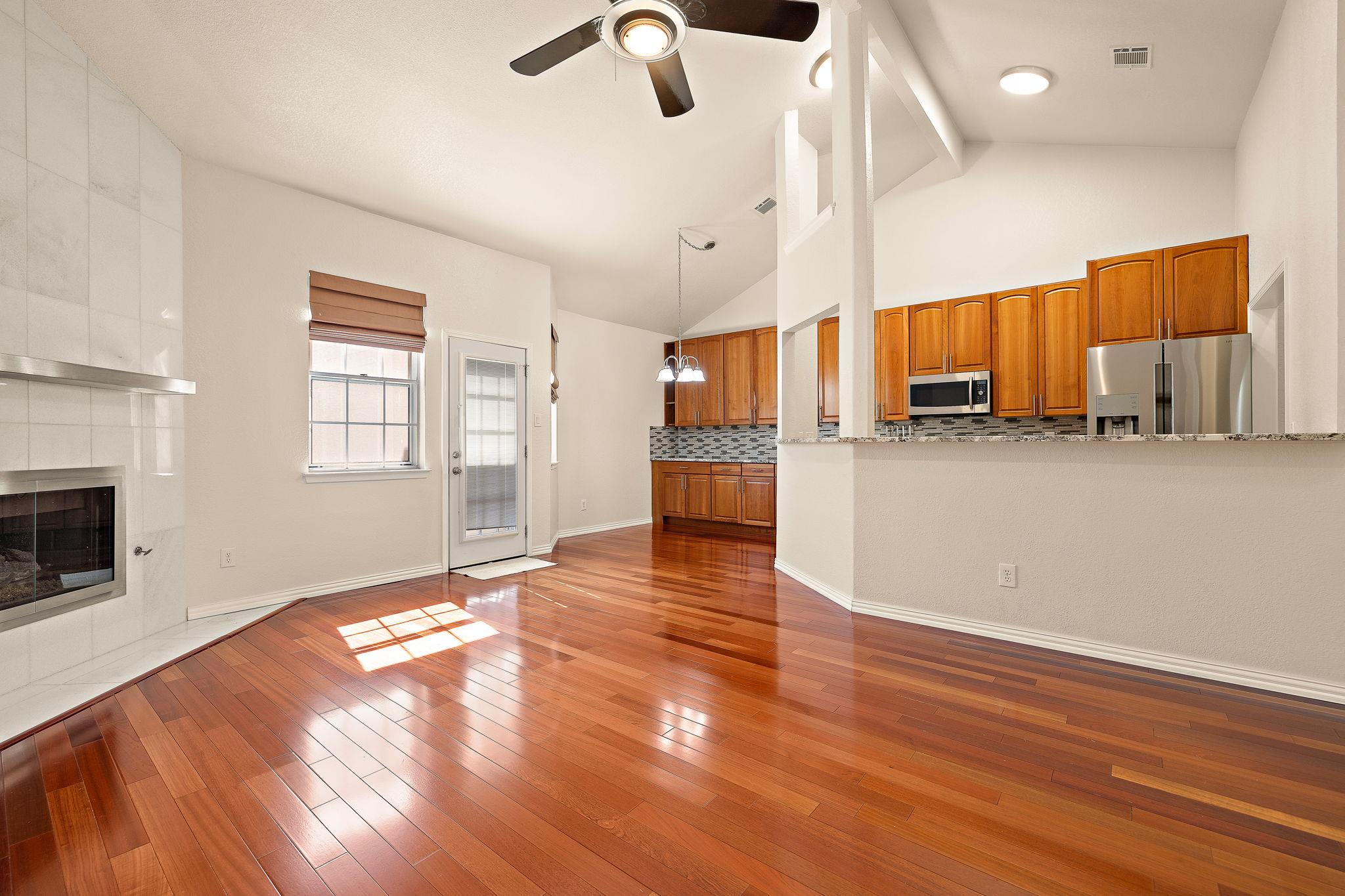 Gleaming hardwood floors and vaulted ceilings anc