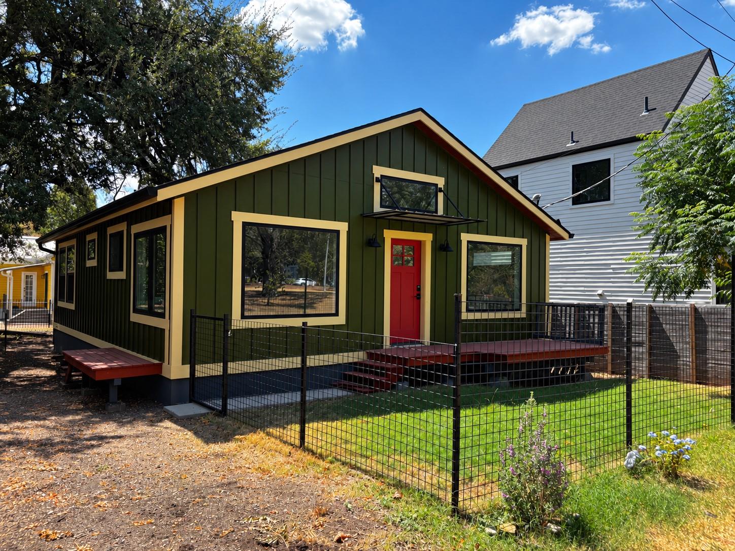 Board and batten siding pairs with a fenced grass