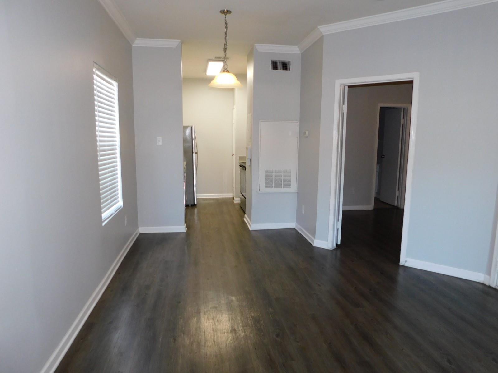 Rich dark wood flooring and crisp crown molding f