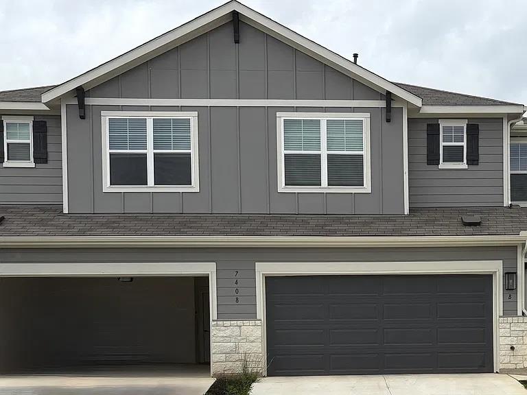 Modern vertical siding and stone accents frame th