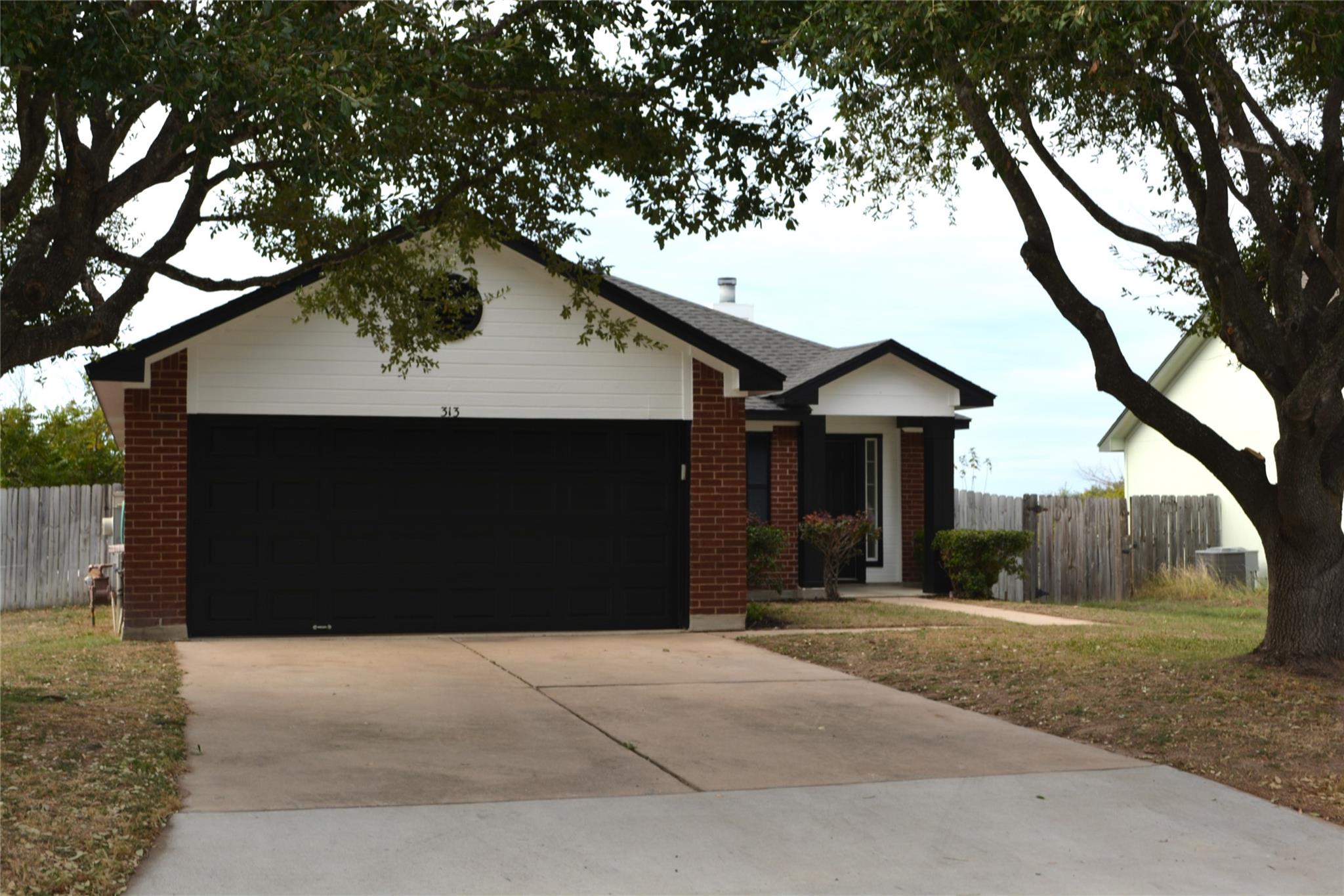 Established shade trees frame this classic brick 