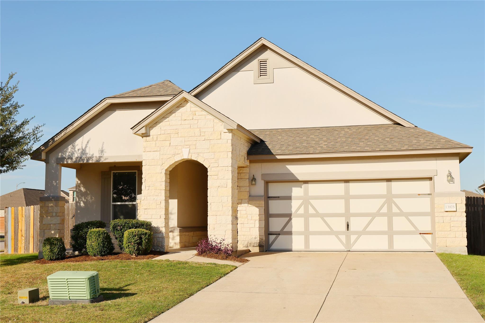 Textured stone accents and a manicured lawn defin