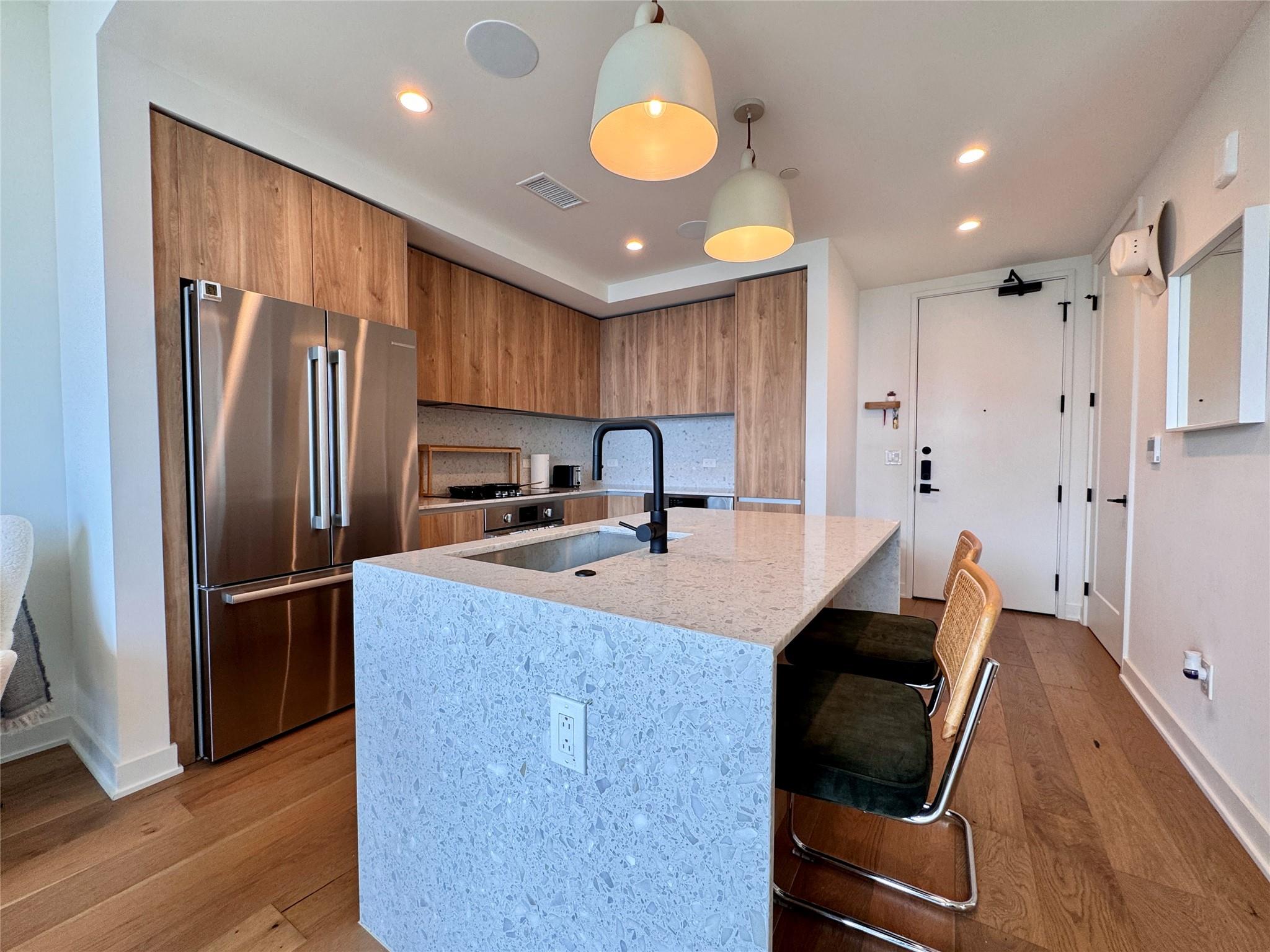 Modern stone countertops and warm wood cabinetry 