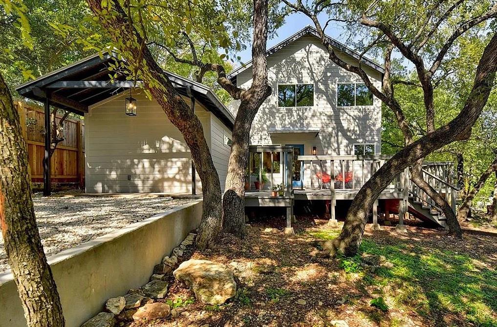 Mature trees shade a multi-level wood deck leadin