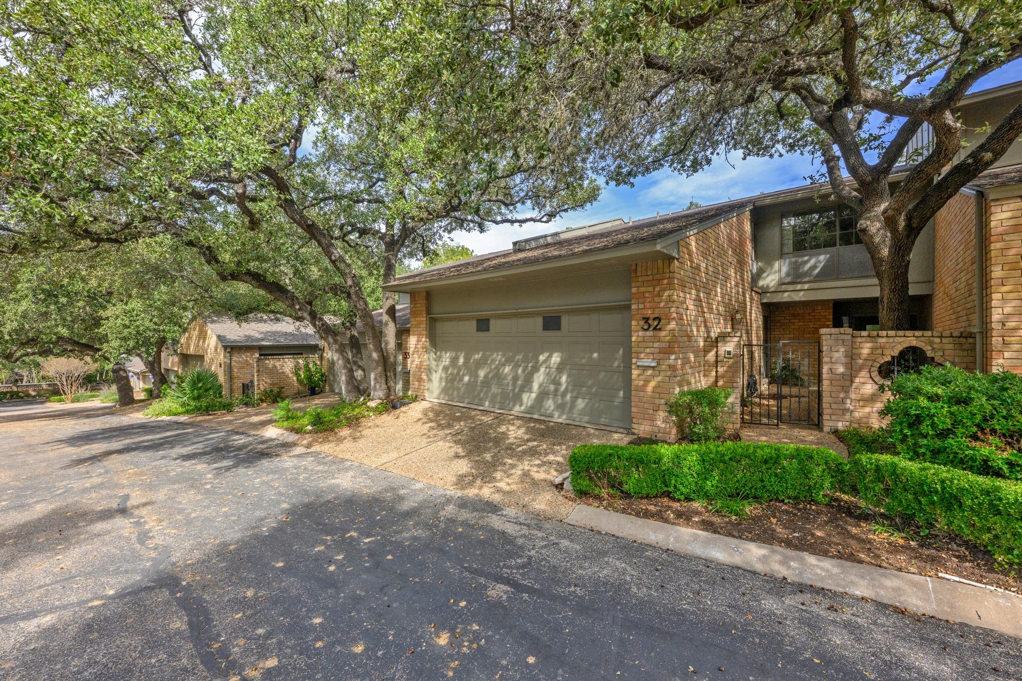 Mature oak trees frame a classic brick exterior w