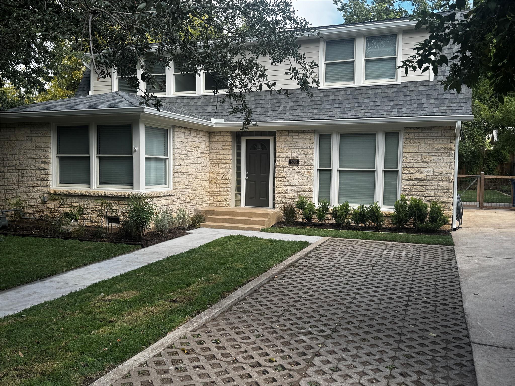 Textured stone veneer and neat concrete pathways 
