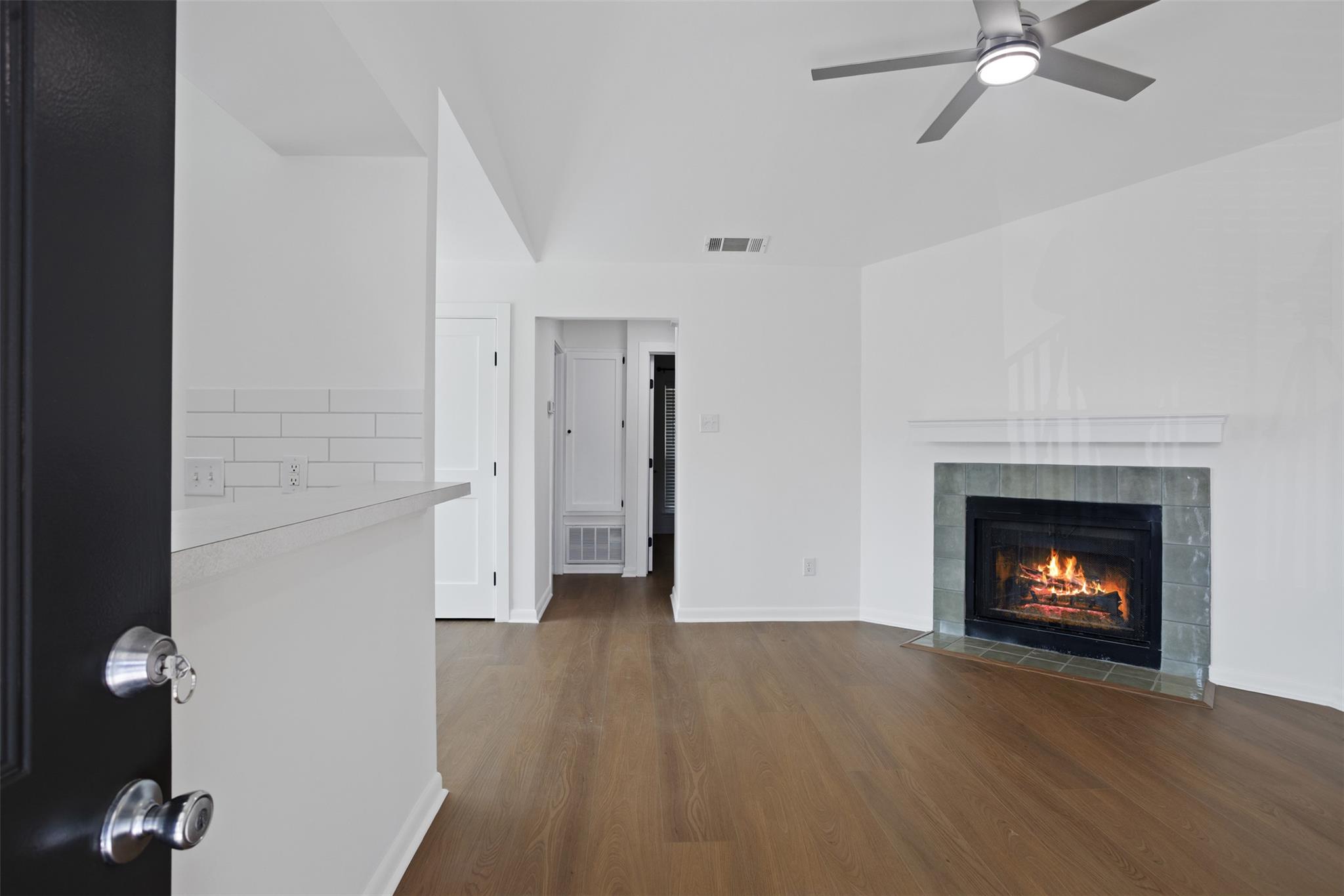 Warm wood flooring and a classic tiled fireplace 