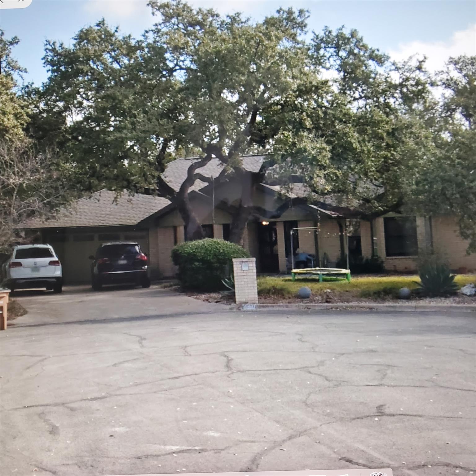 Mature shade trees frame this classic single-stor