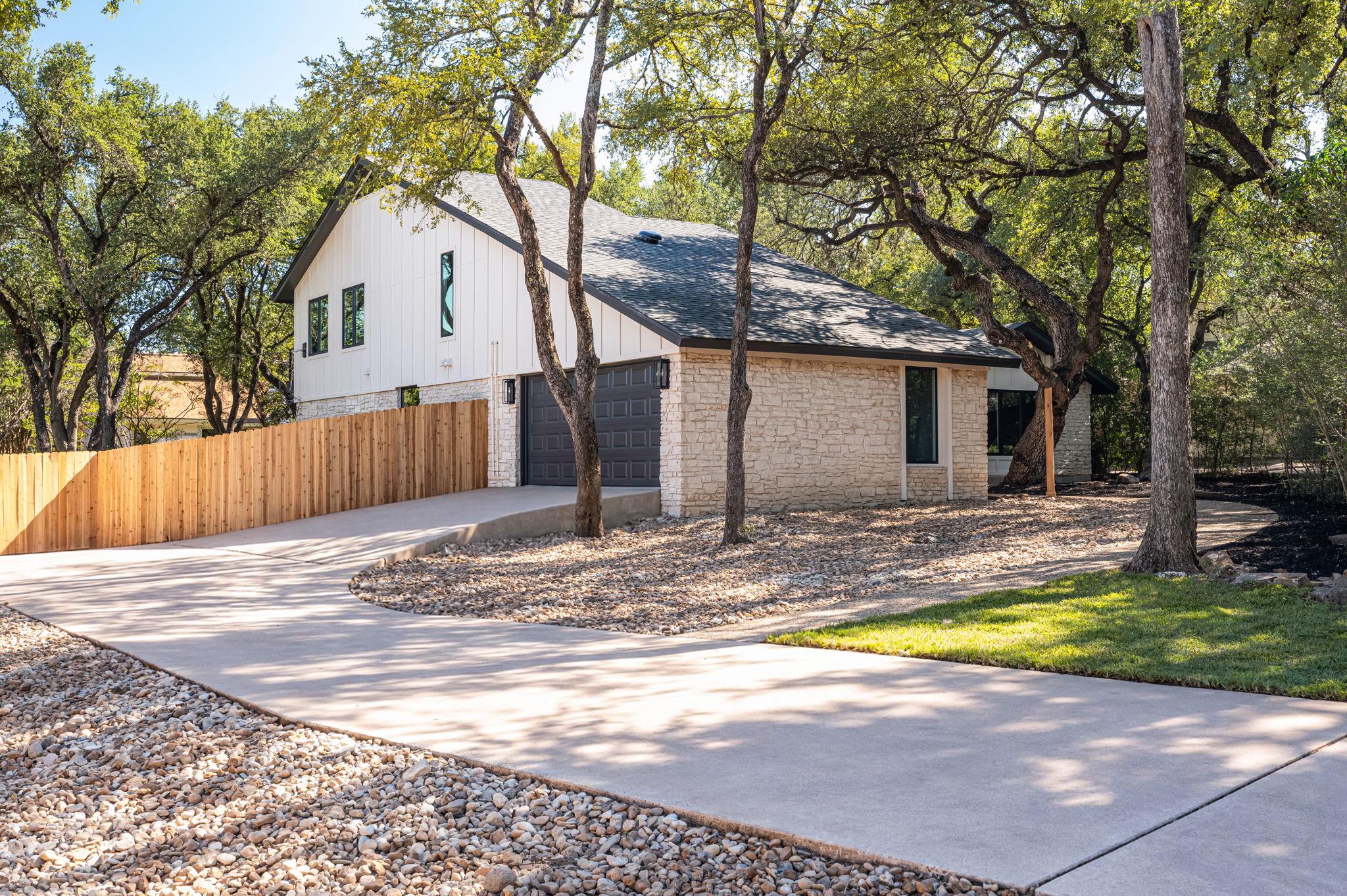 Mature oak trees frame a modern multi-level exter