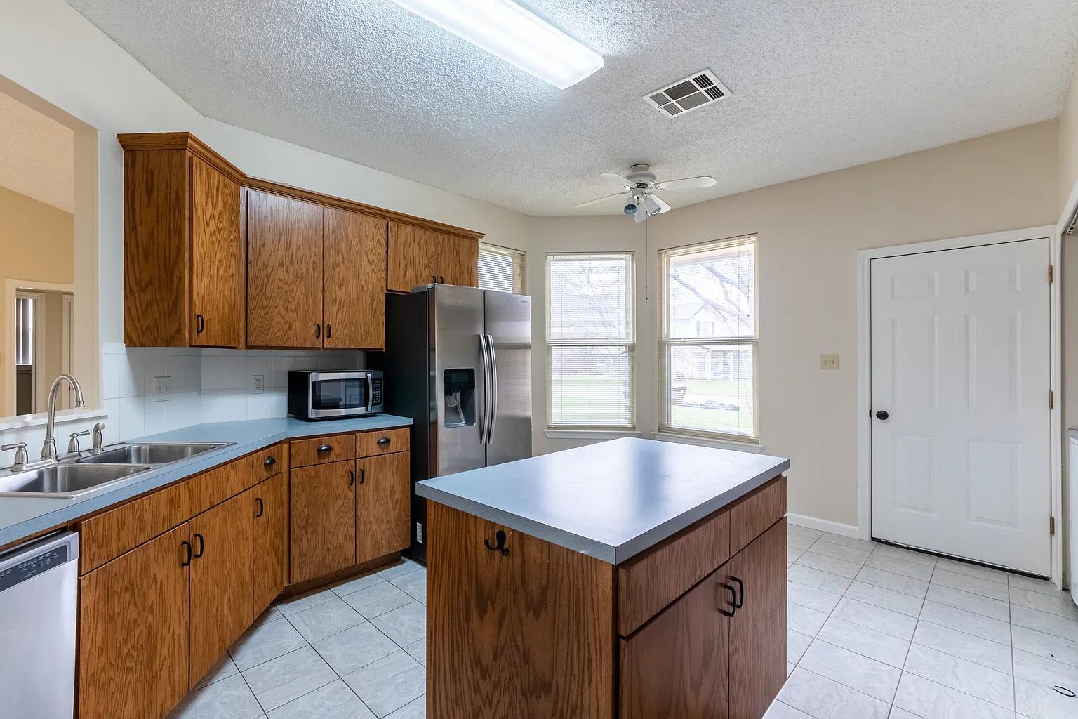 Rich oak cabinetry and a central prep island anch