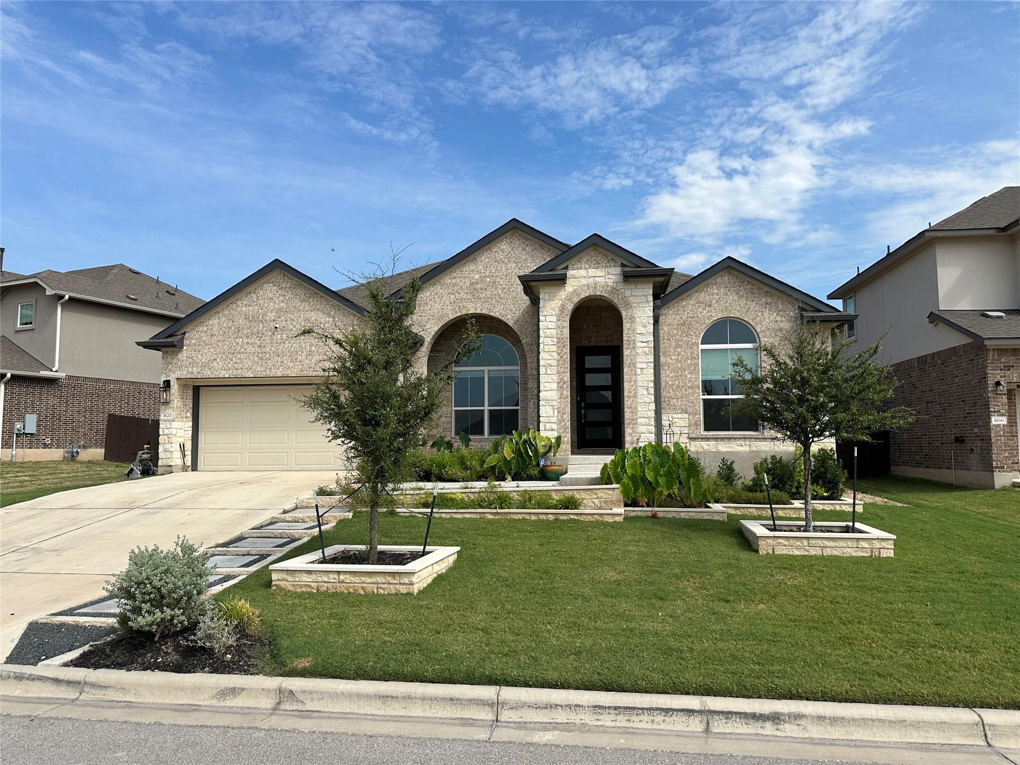 View of front of home with a front yard, an attac
