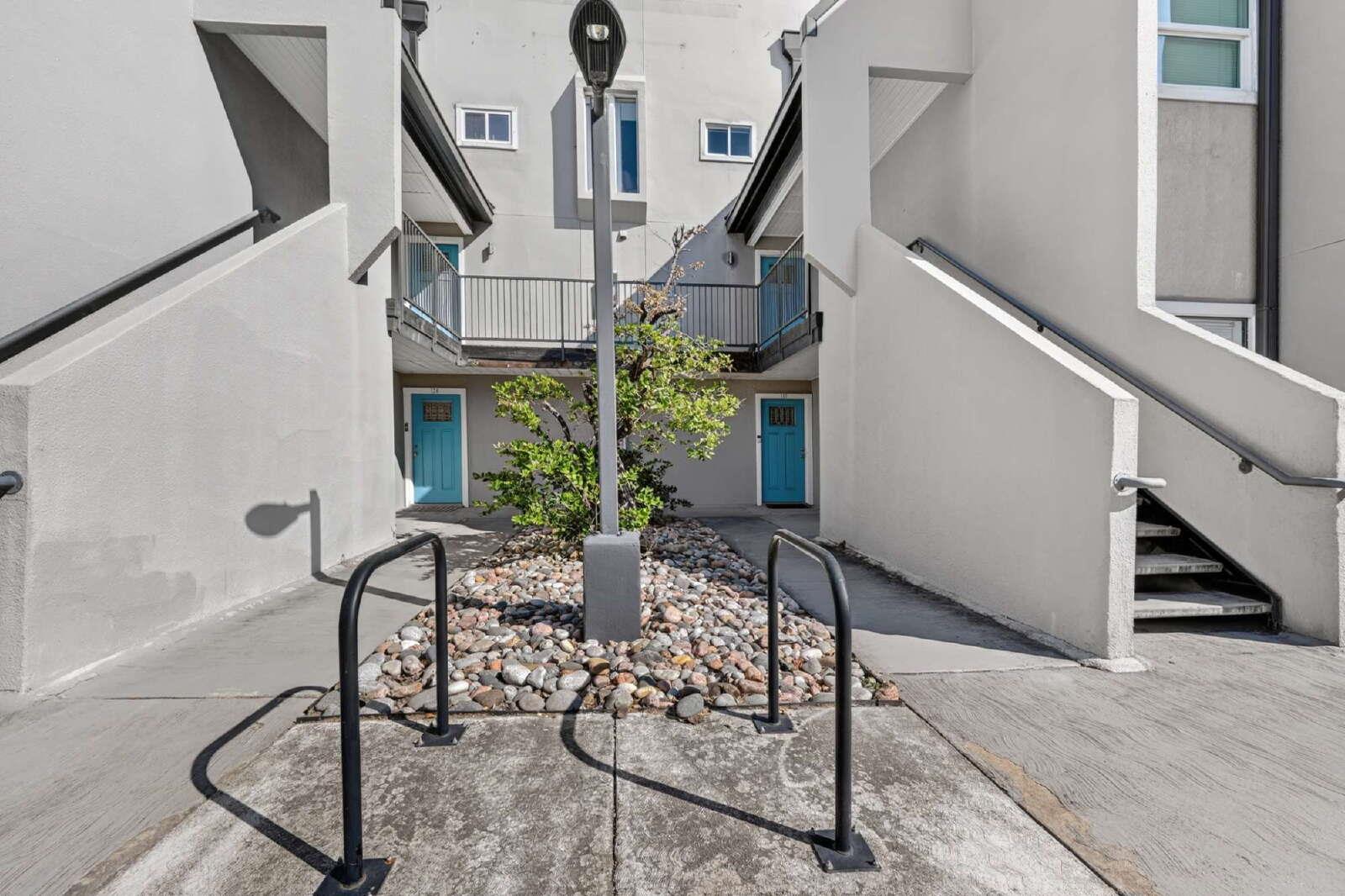 A modern courtyard entrance features concrete pat