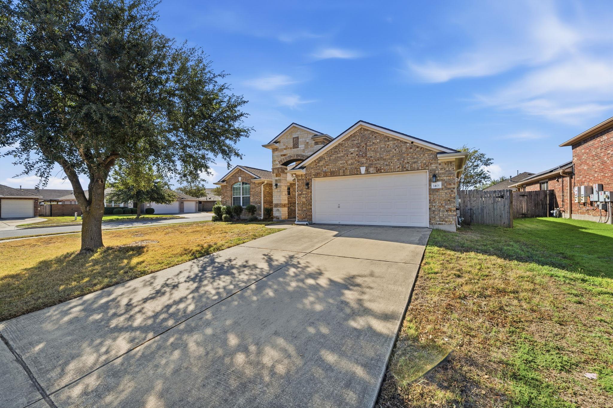 An inviting stone facade and wide concrete drivew