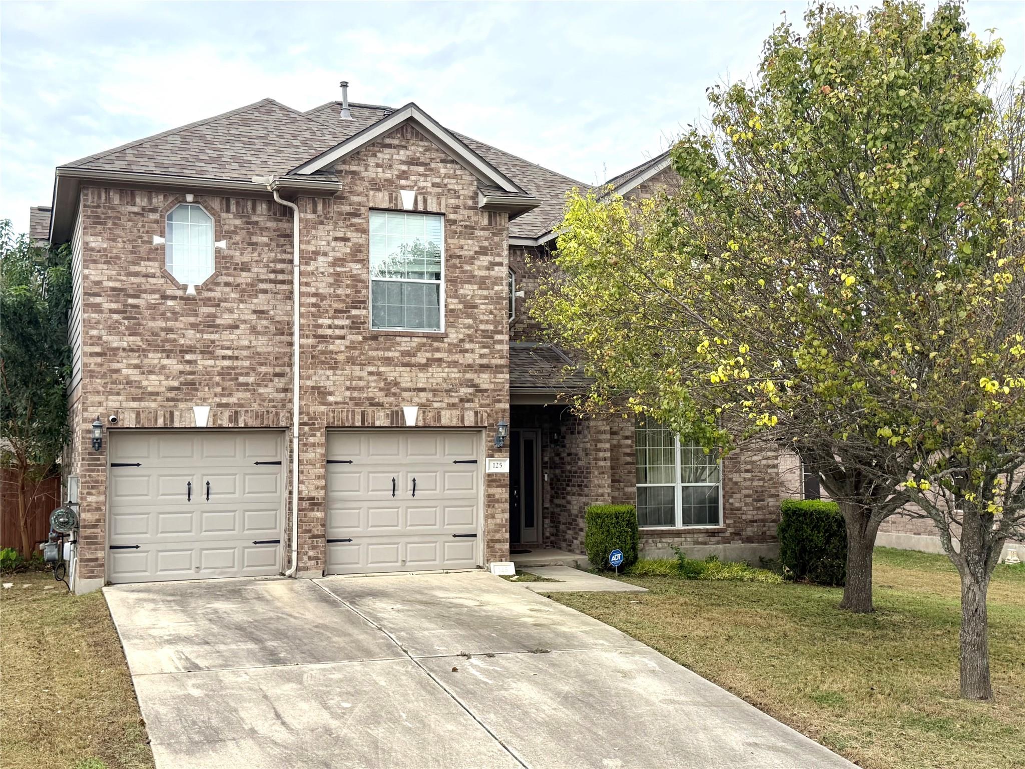 An inviting two-story brick exterior features a s