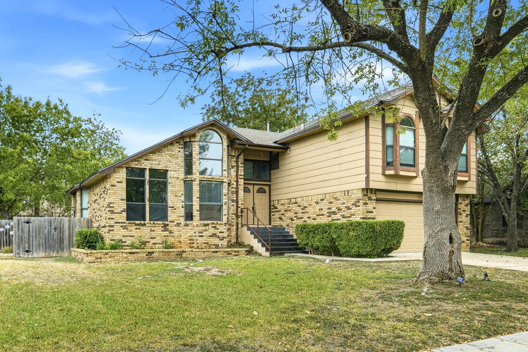 Mature trees and multi-textured siding frame this