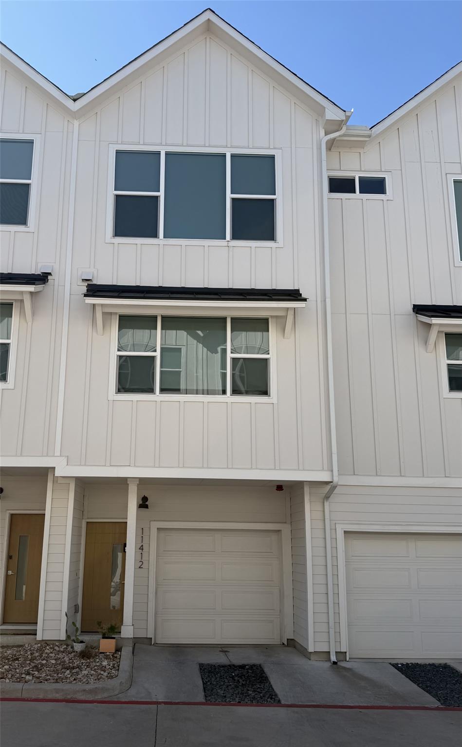 Modern vertical siding and large windows define t