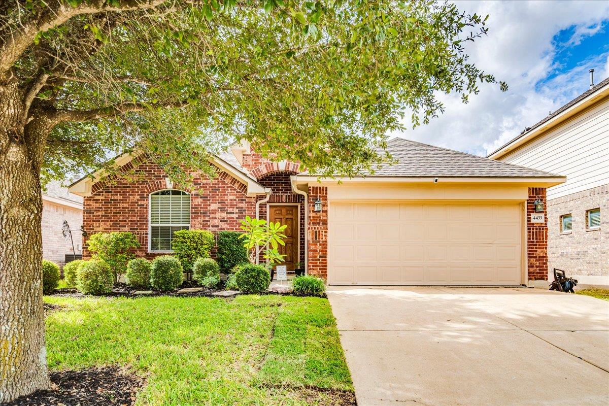 Mature trees shade the classic brick exterior and