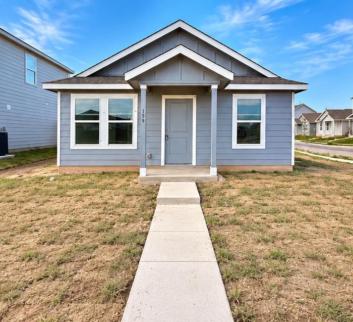 A concrete walkway leads to the covered front por