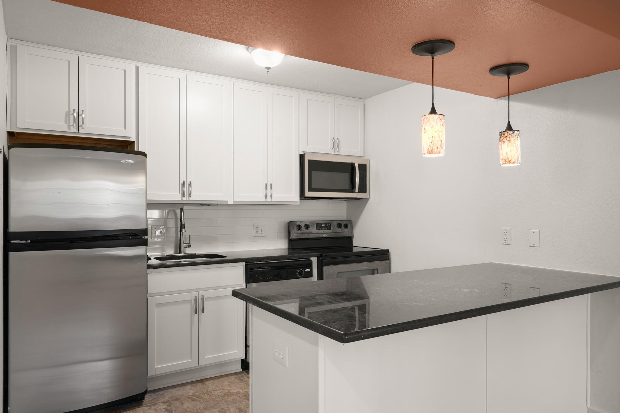Sleek granite countertops and white cabinetry def