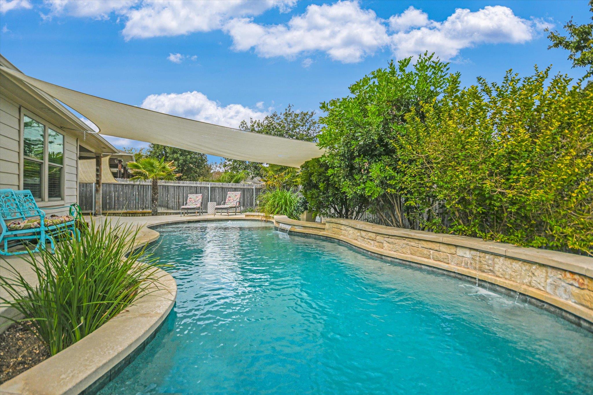 An inviting backyard pool features a custom stone