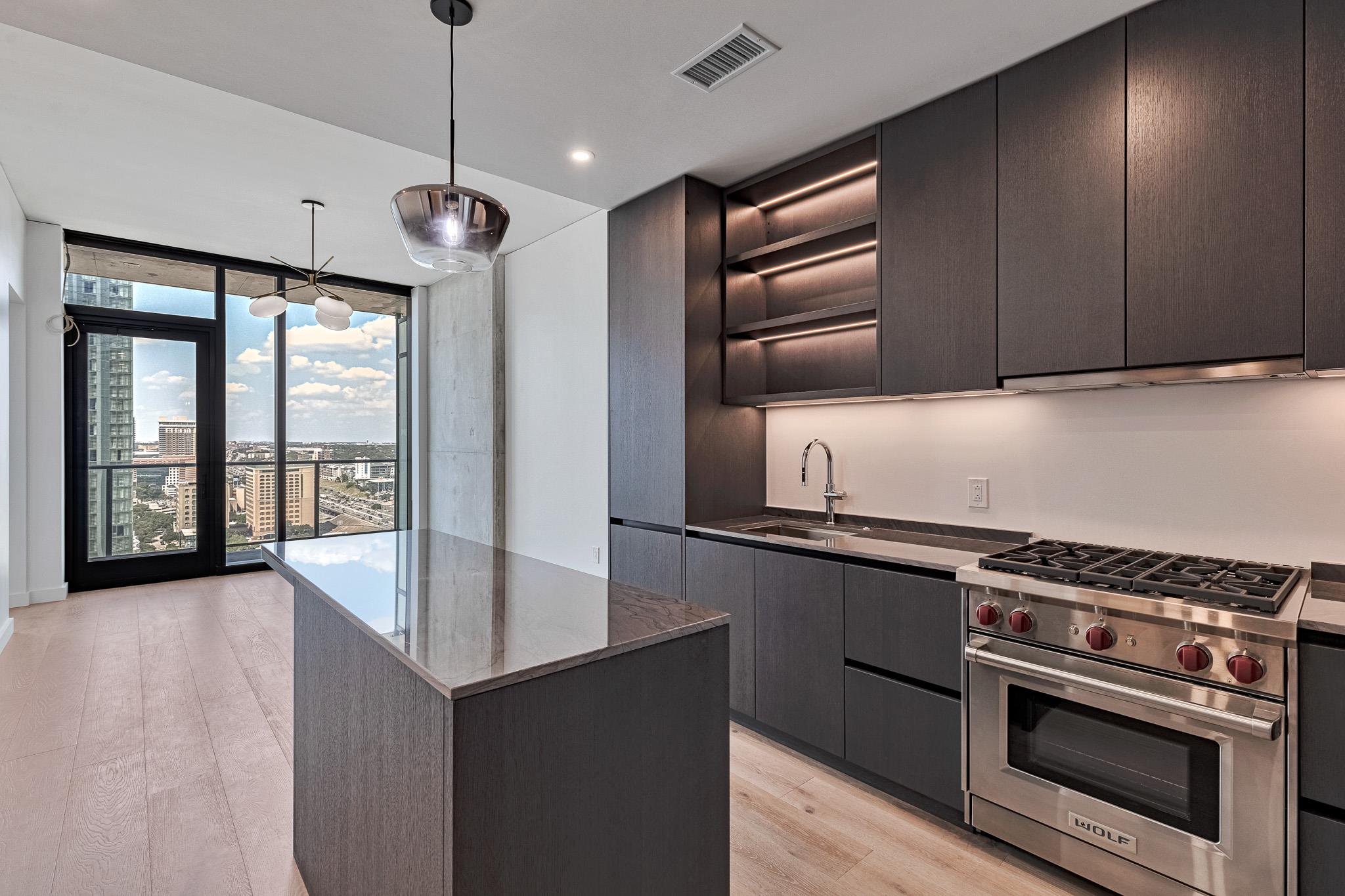 A minimalist kitchen blends sleek dark cabinetry 